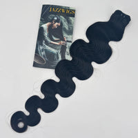 JAZZWIGS Raw Vietnamese body wave hair bundle in natural black, laid diagonally with the curled tips visible.