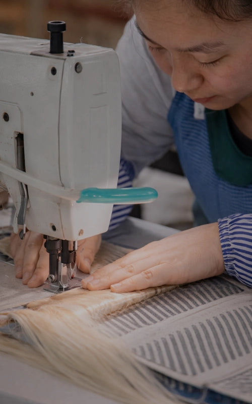 JazzWigs worker sewing human hair wefts during hair production