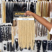 JAZZWIGS #613 Blonde Pixie Curly Feather Crochet Human Hair, multiple hair groups displayed on a hanger in the showroom