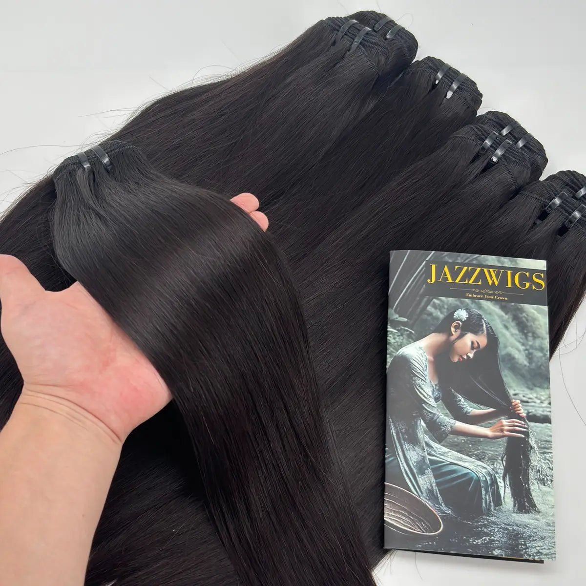 Raw Vietnamese Straight Hair bundle held by hand during product quality check with additional bundles in the background.