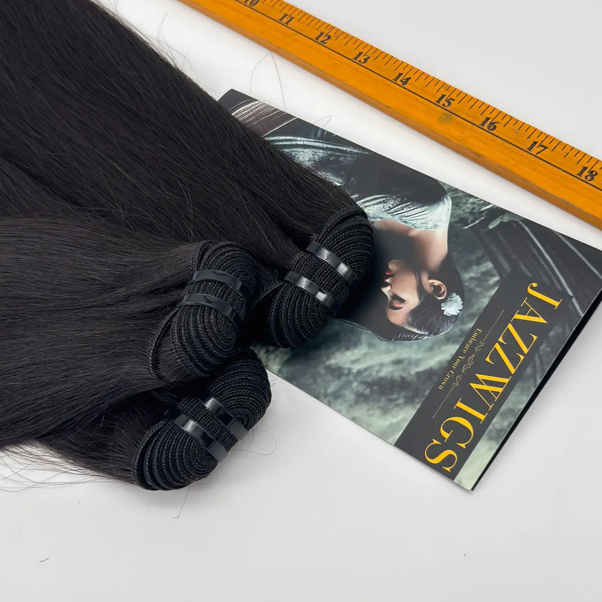 Close-up of JazzWigs Raw Vietnamese Straight Hair bundle wefts and machine-sewn tracks with measuring ruler.
